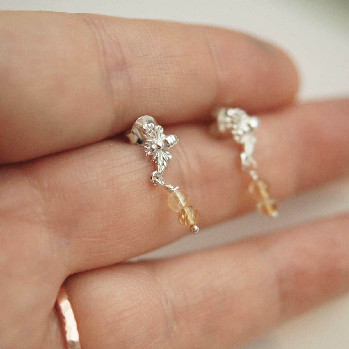 Silver earrings with small beads on a hand