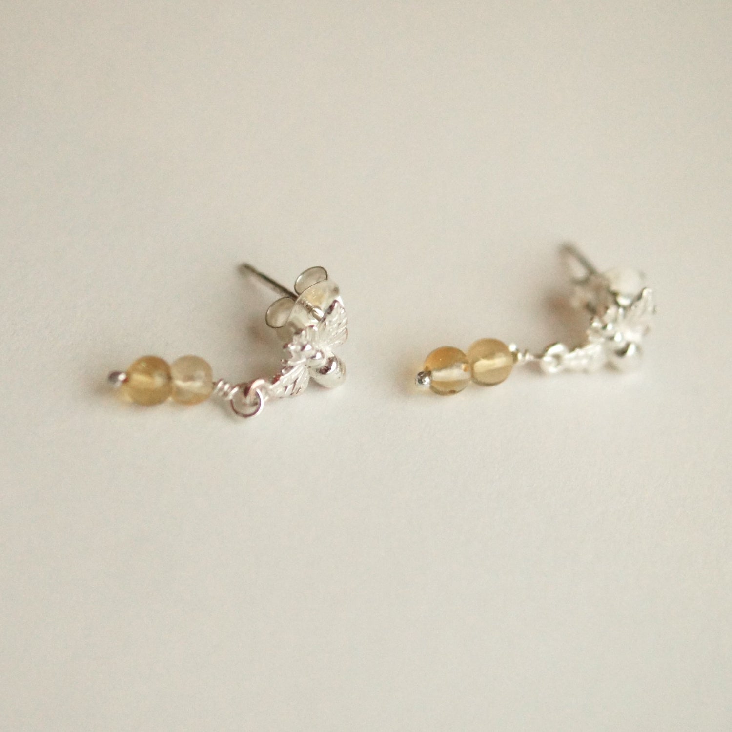 Pair of silver and gold beaded earrings on a light background