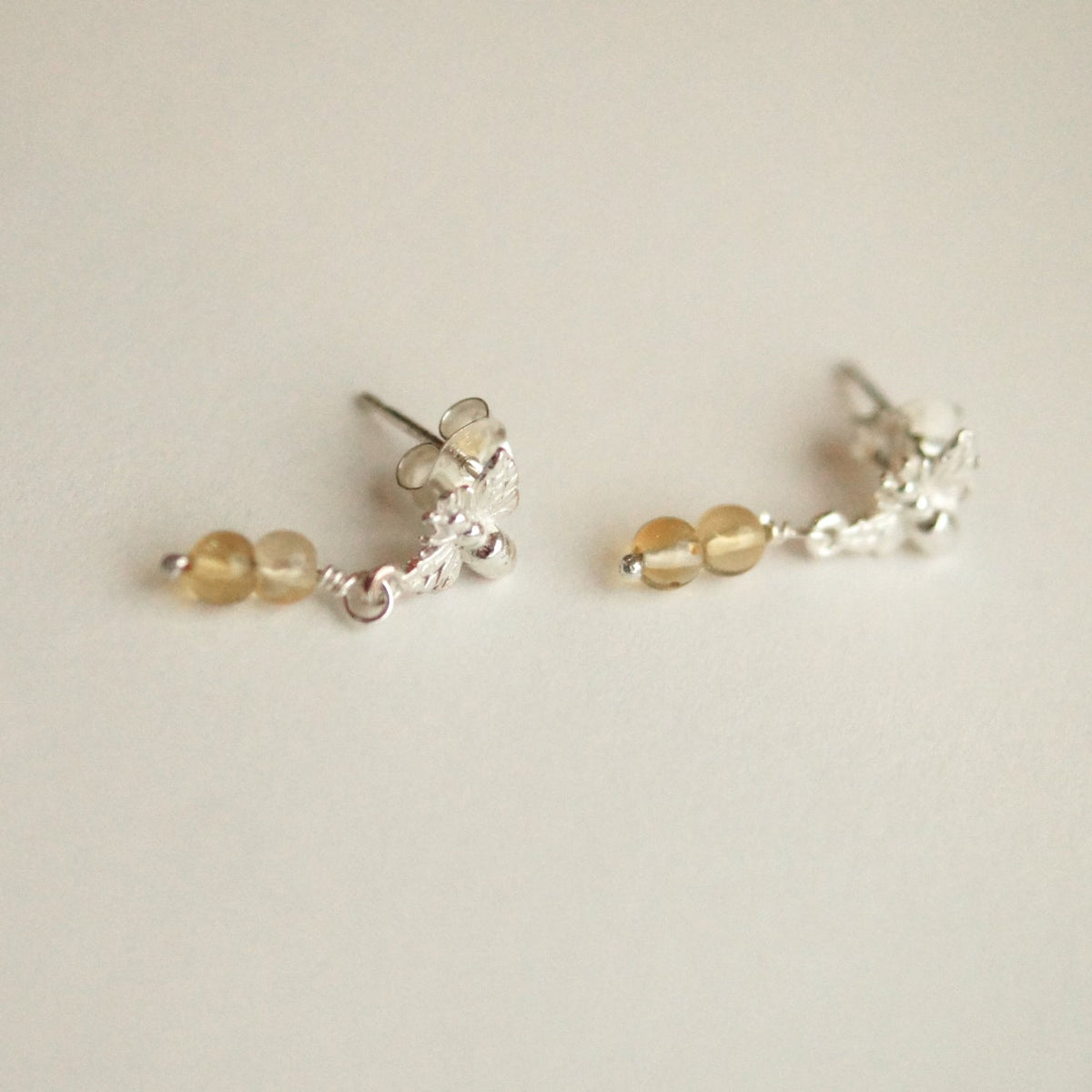 Pair of silver and gold beaded earrings on a light background