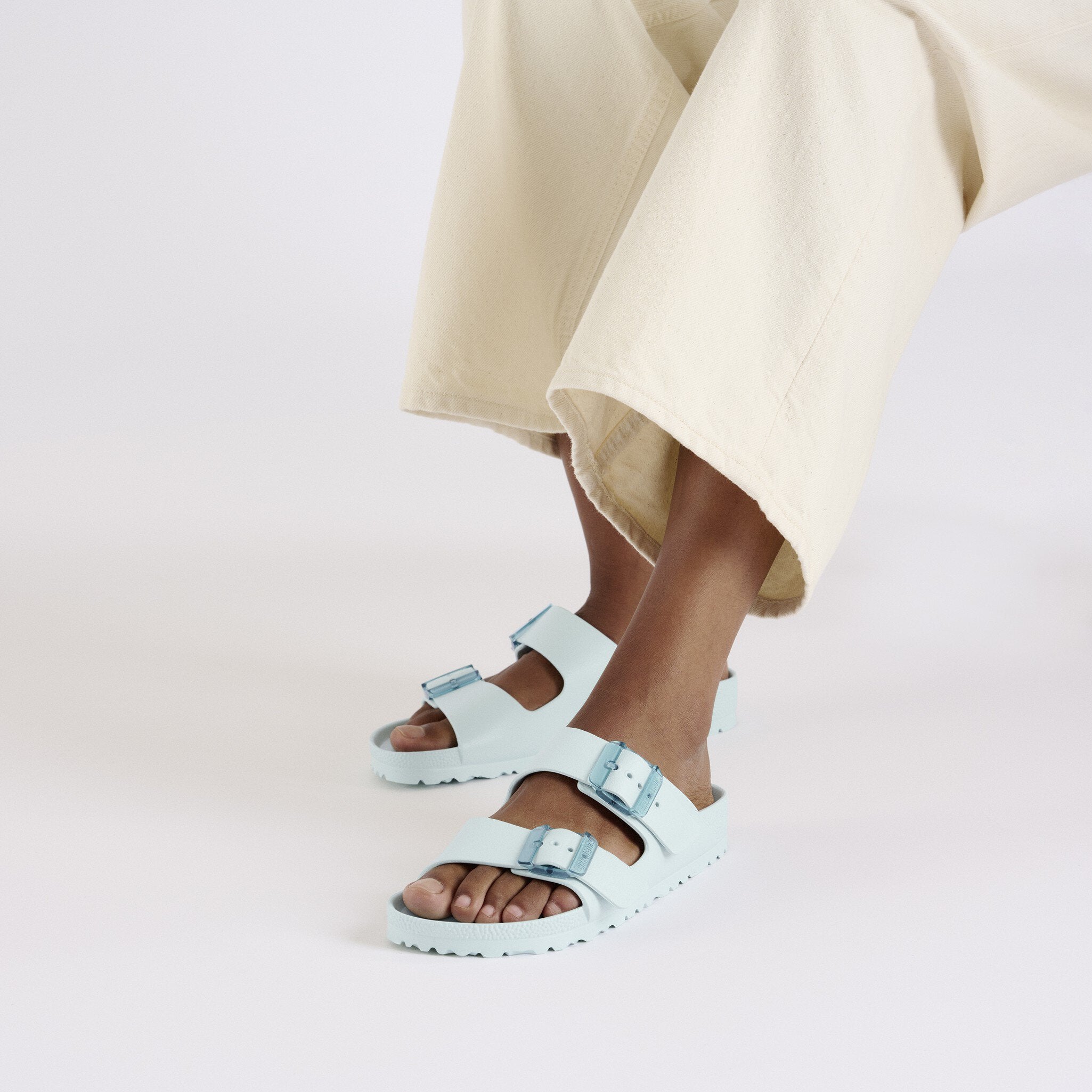 Birkenstock Arizona Stealth EVA Surf Green sandals worn with loose beige pants, showcasing lightweight and flexible design.