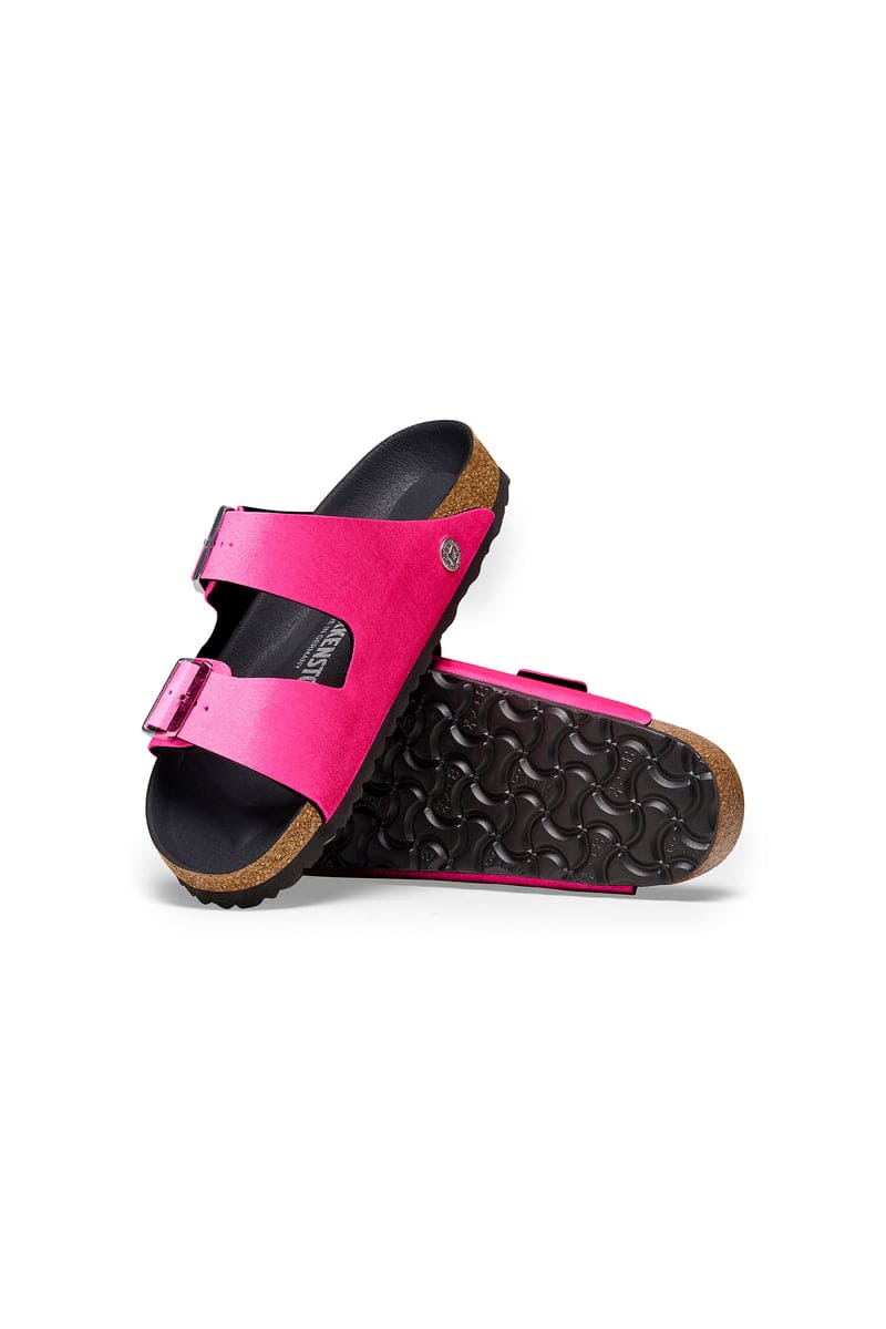 Birkenstock Women's Arizona Sandals in bright pink with rivet buckles and smooth black footbed, top view.