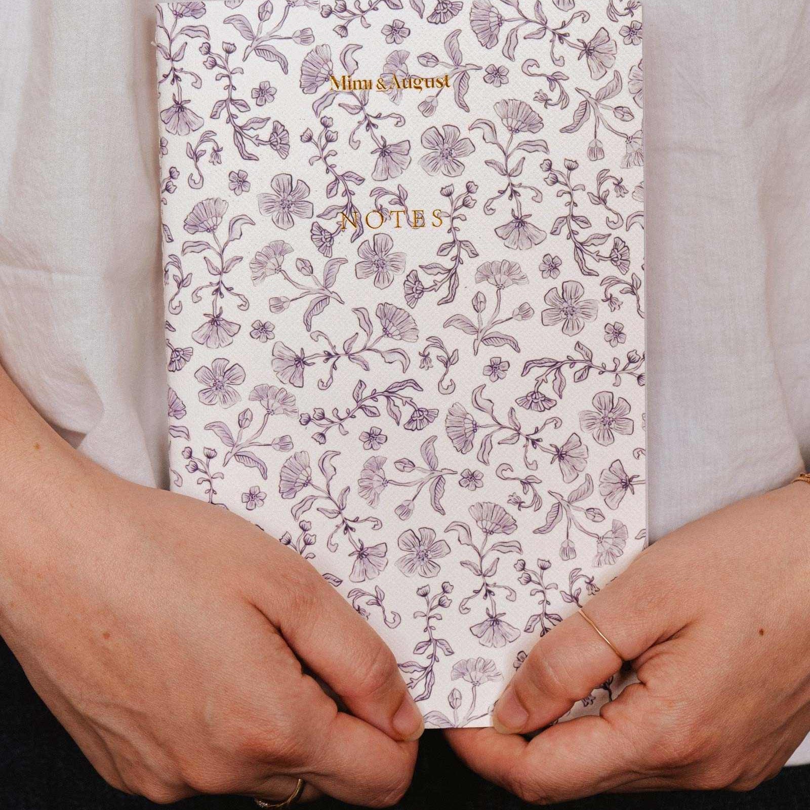 mimi-and-august Person holding a floral notebook with 'Notes' text