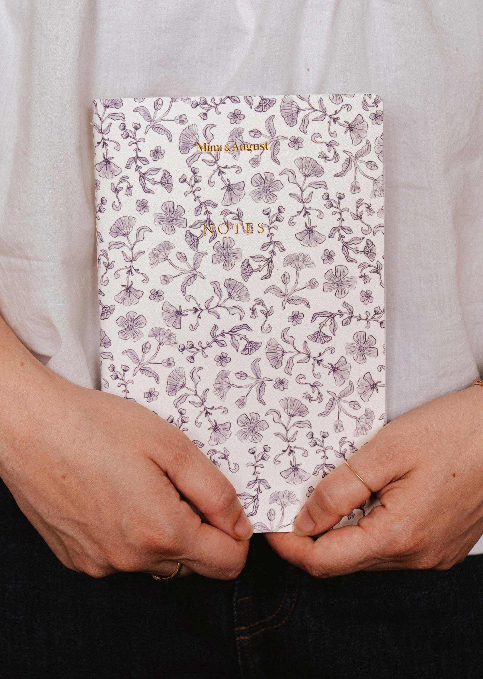 mimi-and-august Person holding a floral notebook with 'Notes' text