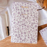 mimi-and-august Floral-patterned notebook on a wooden surface with a pen and decorative elements.