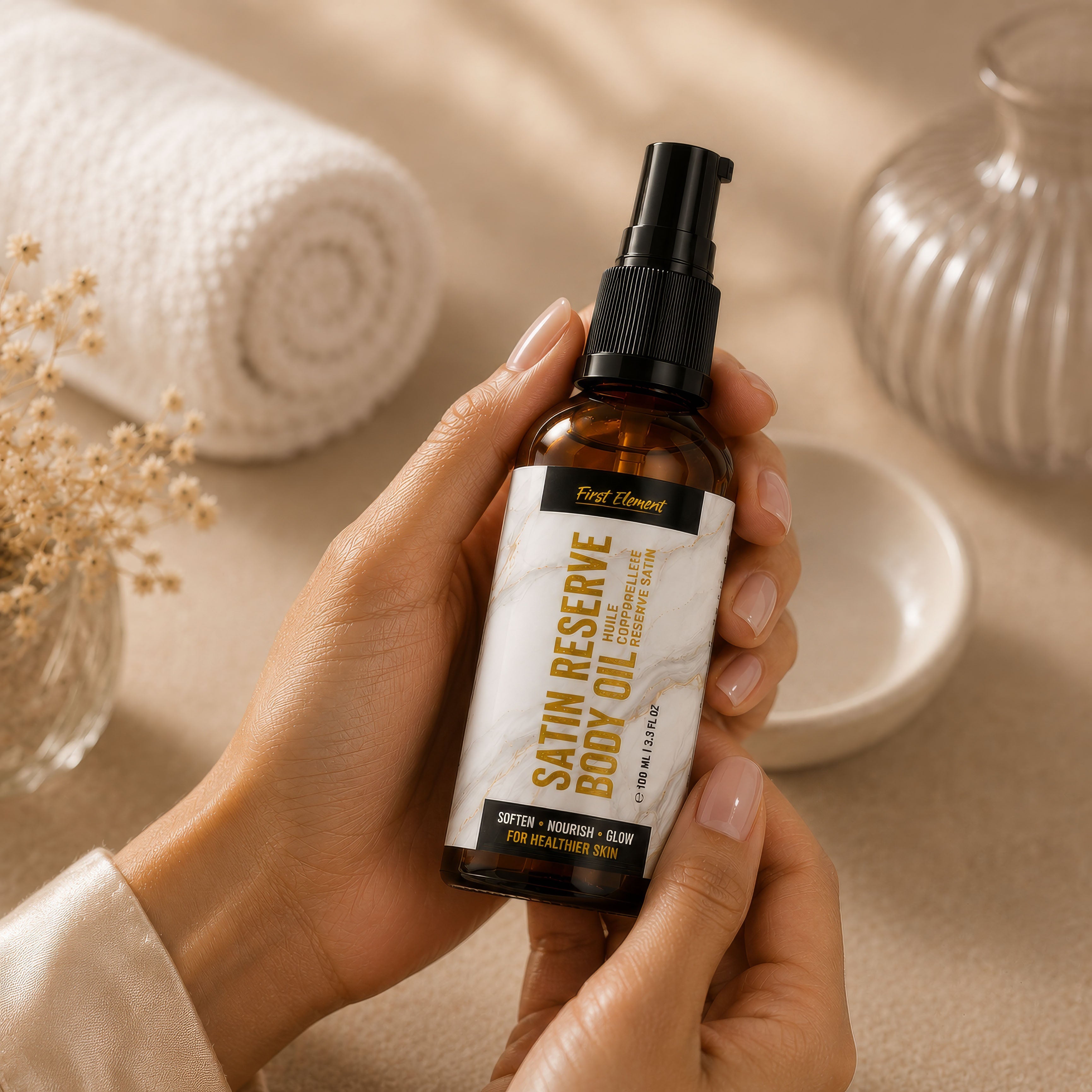 Hand holding a bottle of Satin Reserve body oil with a neutral background