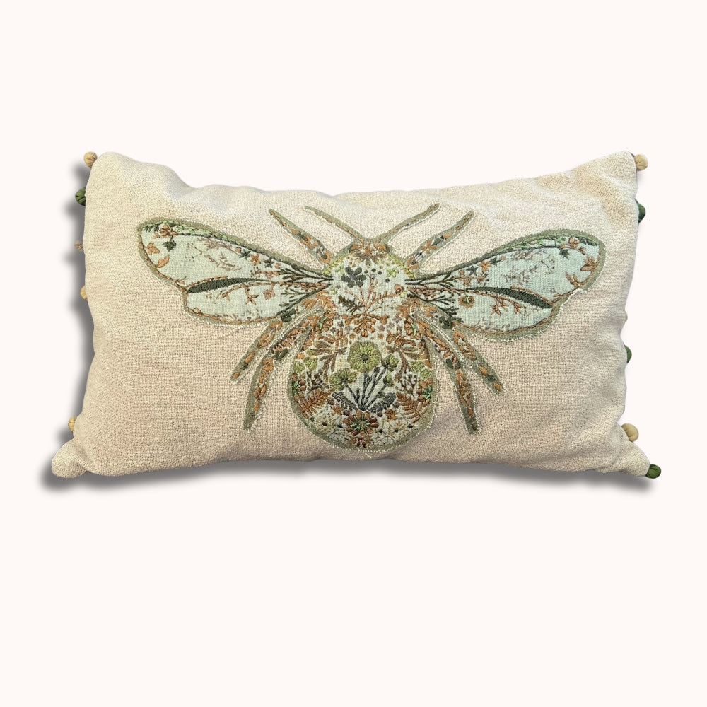 Decorative pillow with a bee design on a beige background