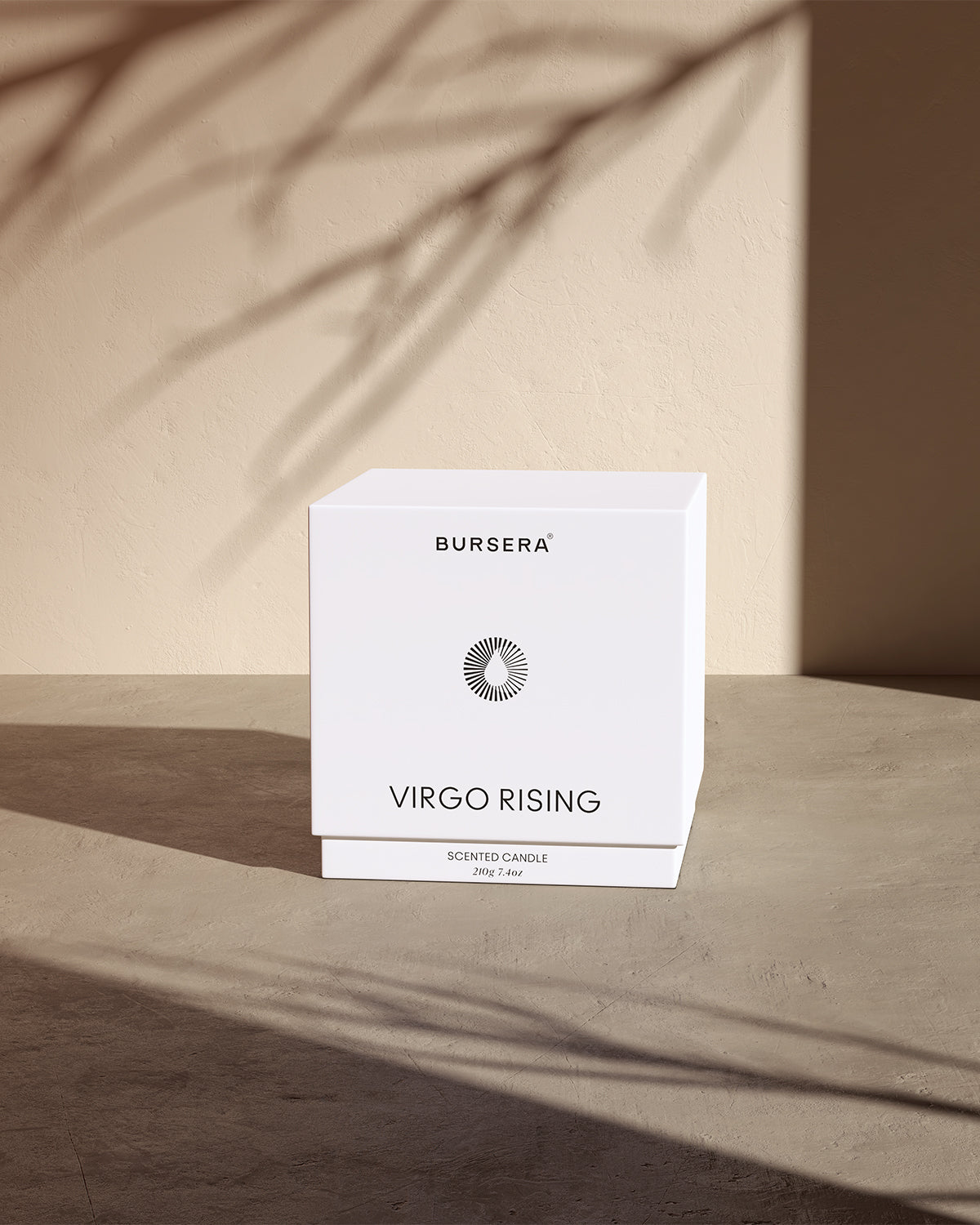Bursera Desert Rose scented candle packaging on a wooden surface with a neutral background