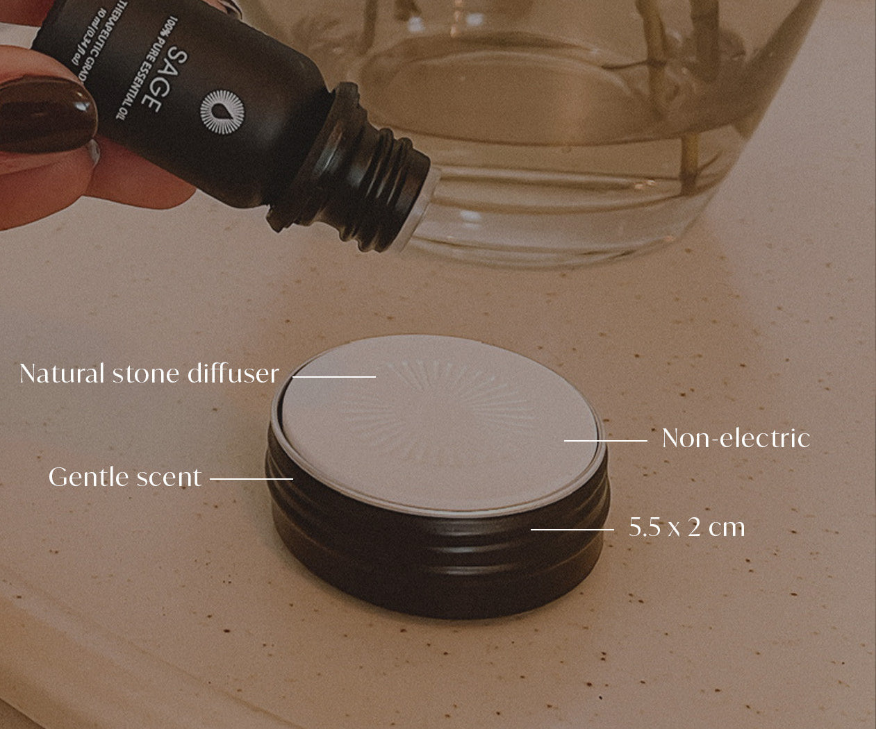 Hand holding a diffuser bottle with product details on a stone surface