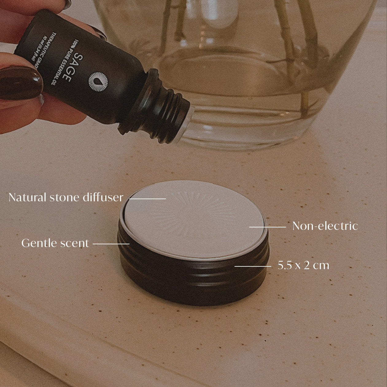 Hand holding a diffuser bottle with product details on a stone surface