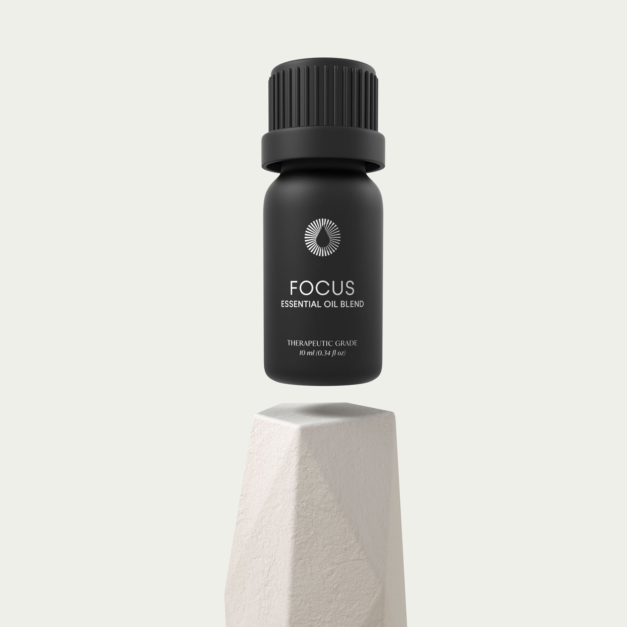 Black essential oil bottle labeled 'Focus' on a light gray background