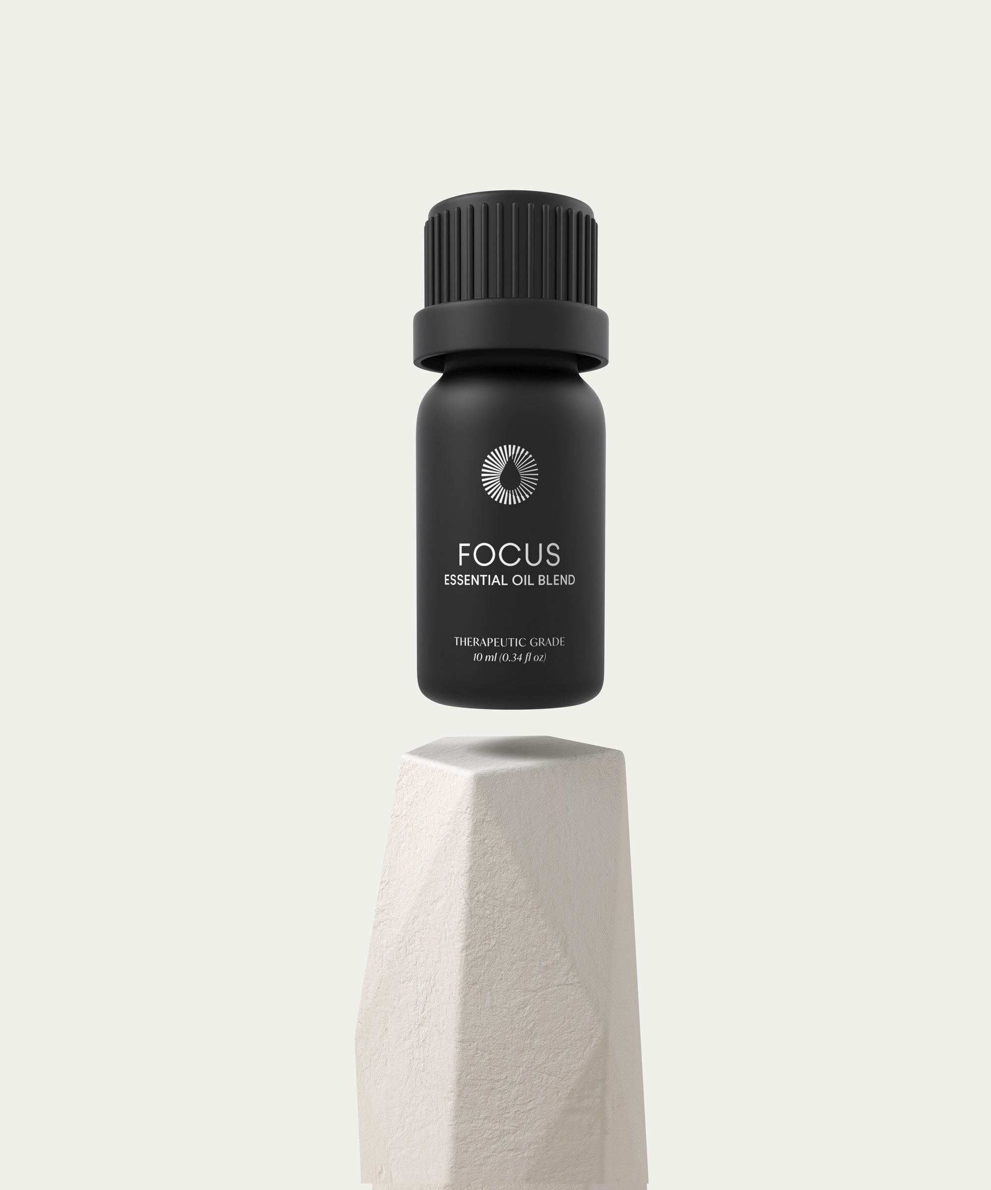 Black essential oil bottle labeled 'Focus' on a light gray background