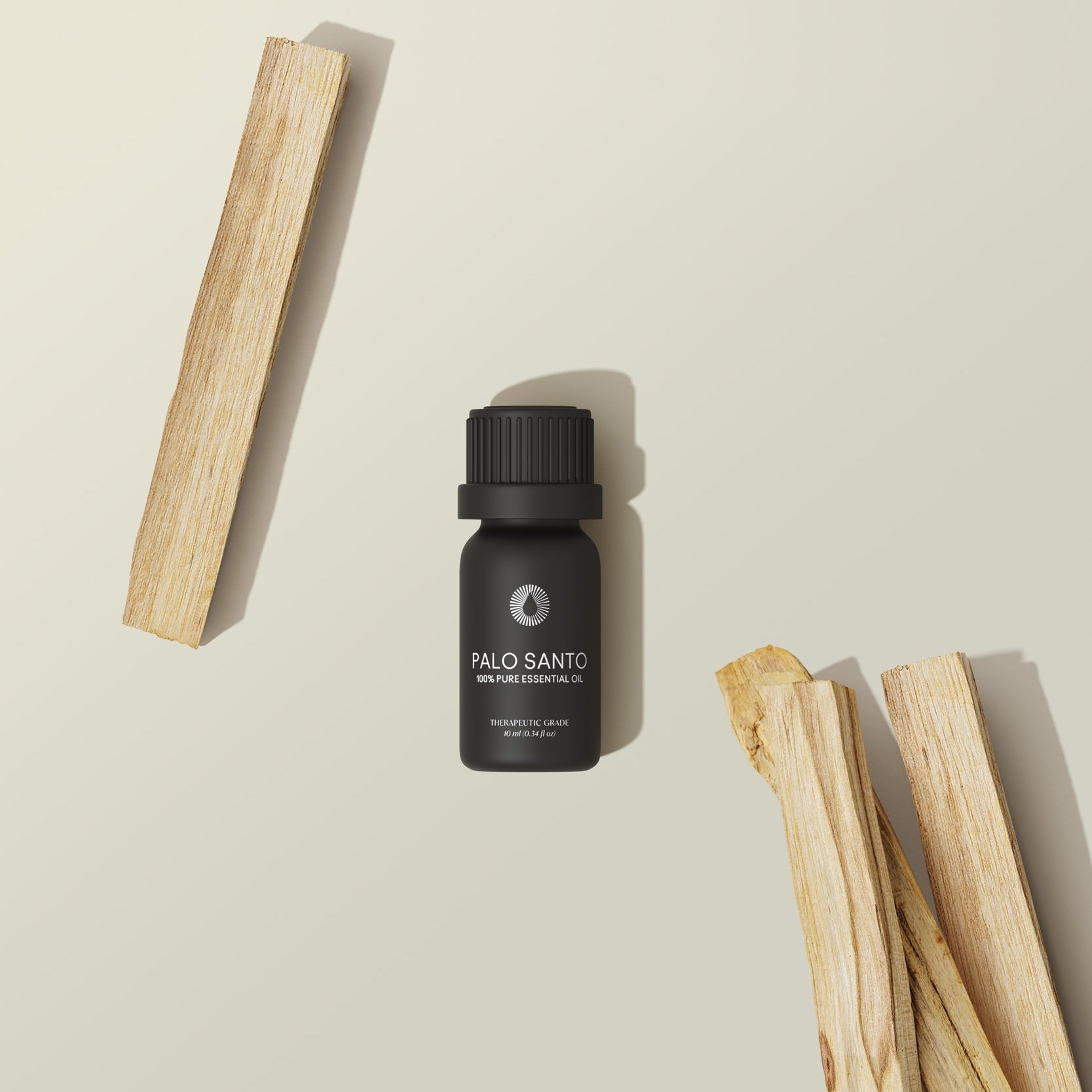 Palo Santo oil bottle with wooden sticks on a beige background