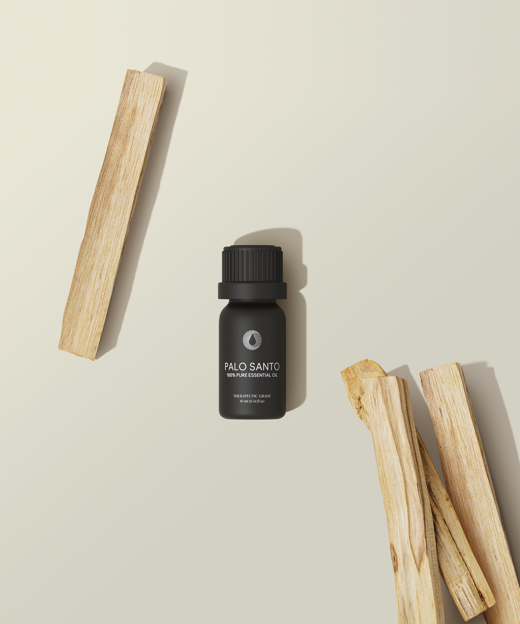 Palo Santo oil bottle with wooden sticks on a beige background