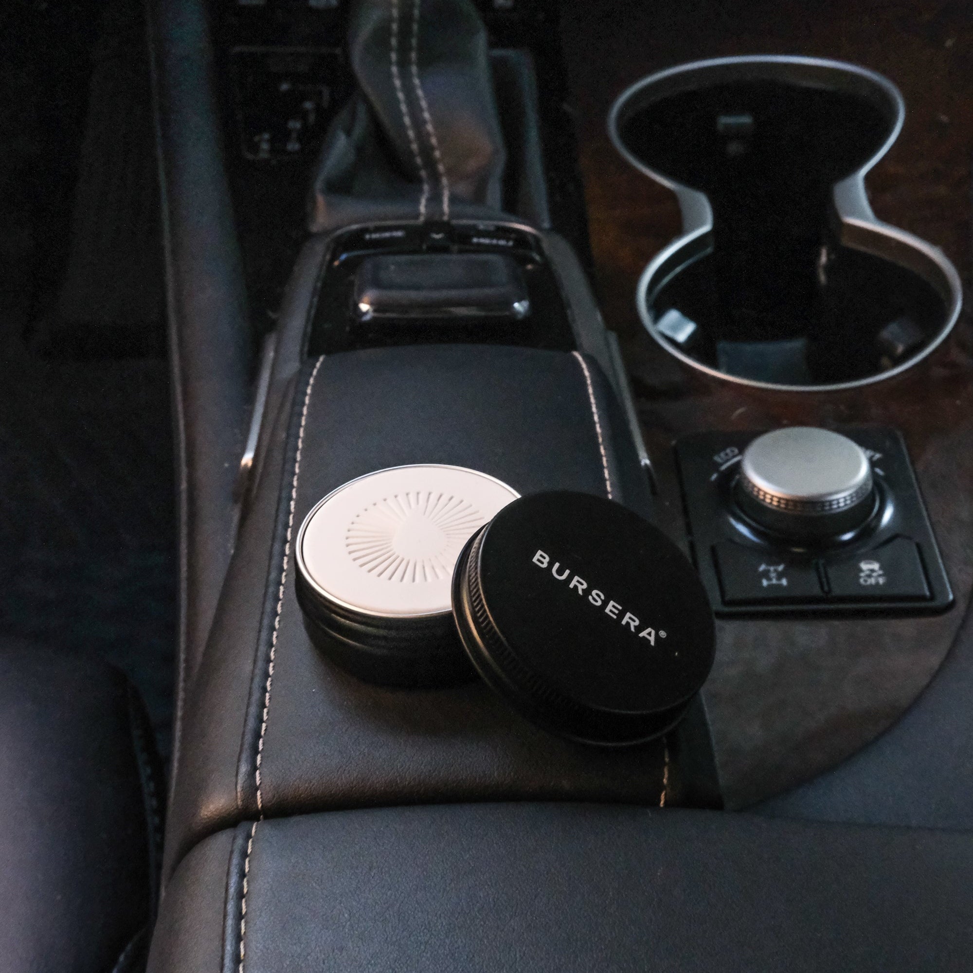 Burgsera car coasters on a car's center console with a cup holder in the background.