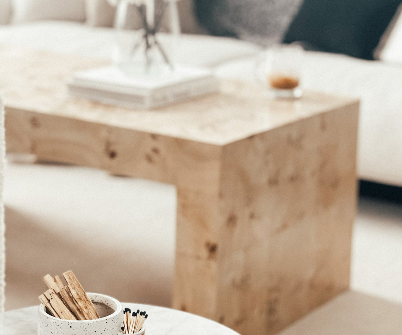 Wooden coffee table with a decorative item on a white surface, blurred background