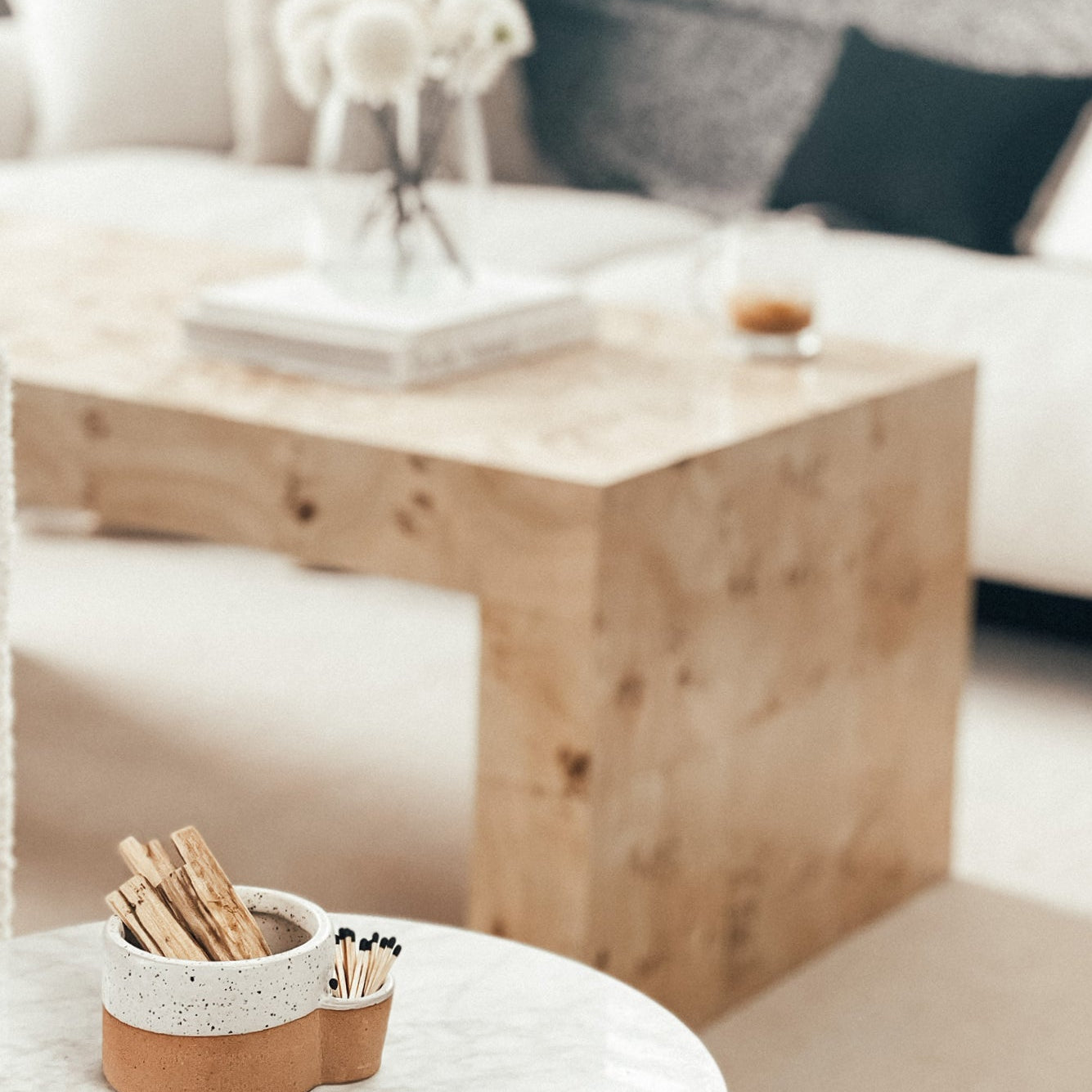 Wooden coffee table with a decorative item on a white surface, blurred background