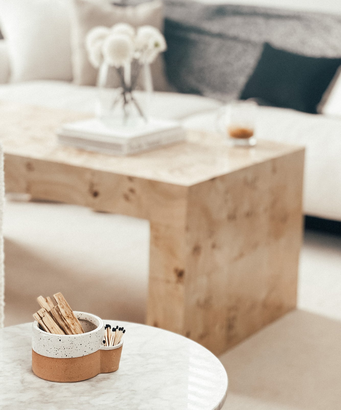 Wooden coffee table with a decorative item on a white surface, blurred background