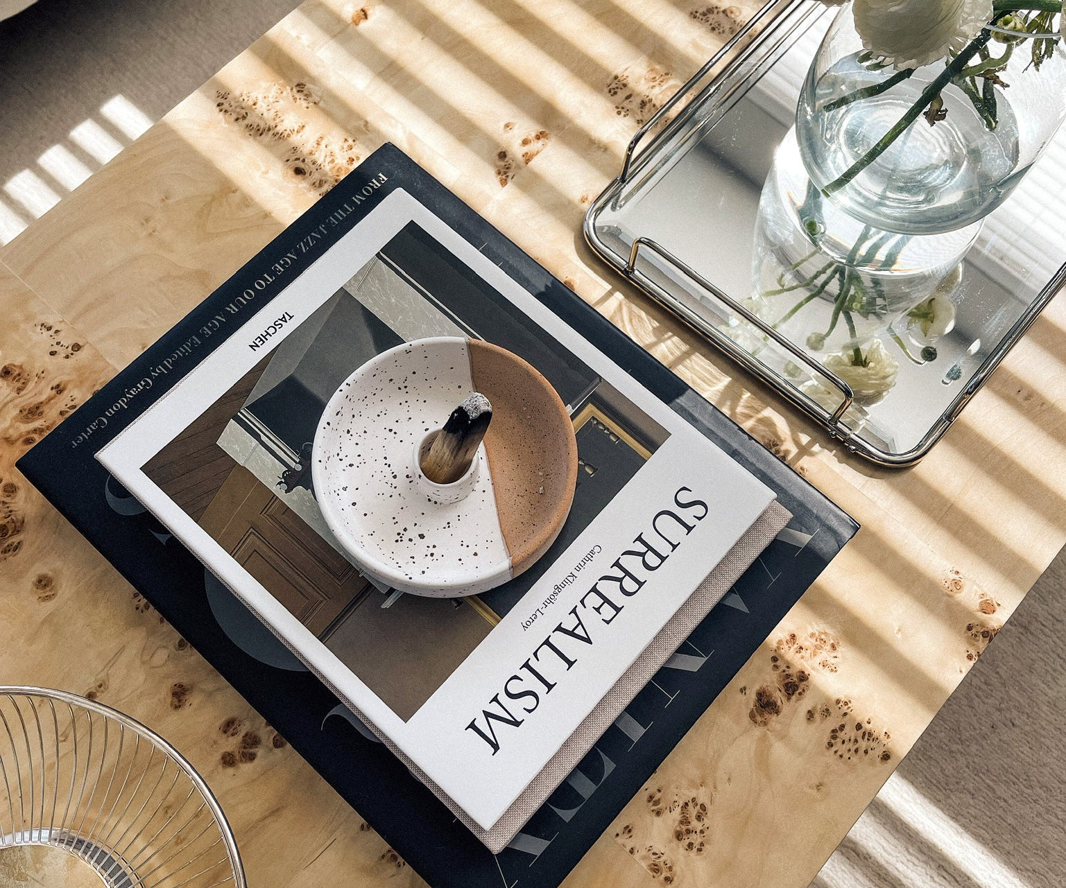 Book titled 'Surreal' on a wooden table with decorative items.