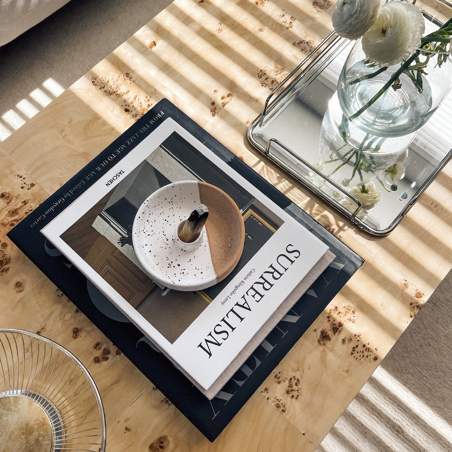 Book titled 'Surreal' on a wooden table with decorative items.
