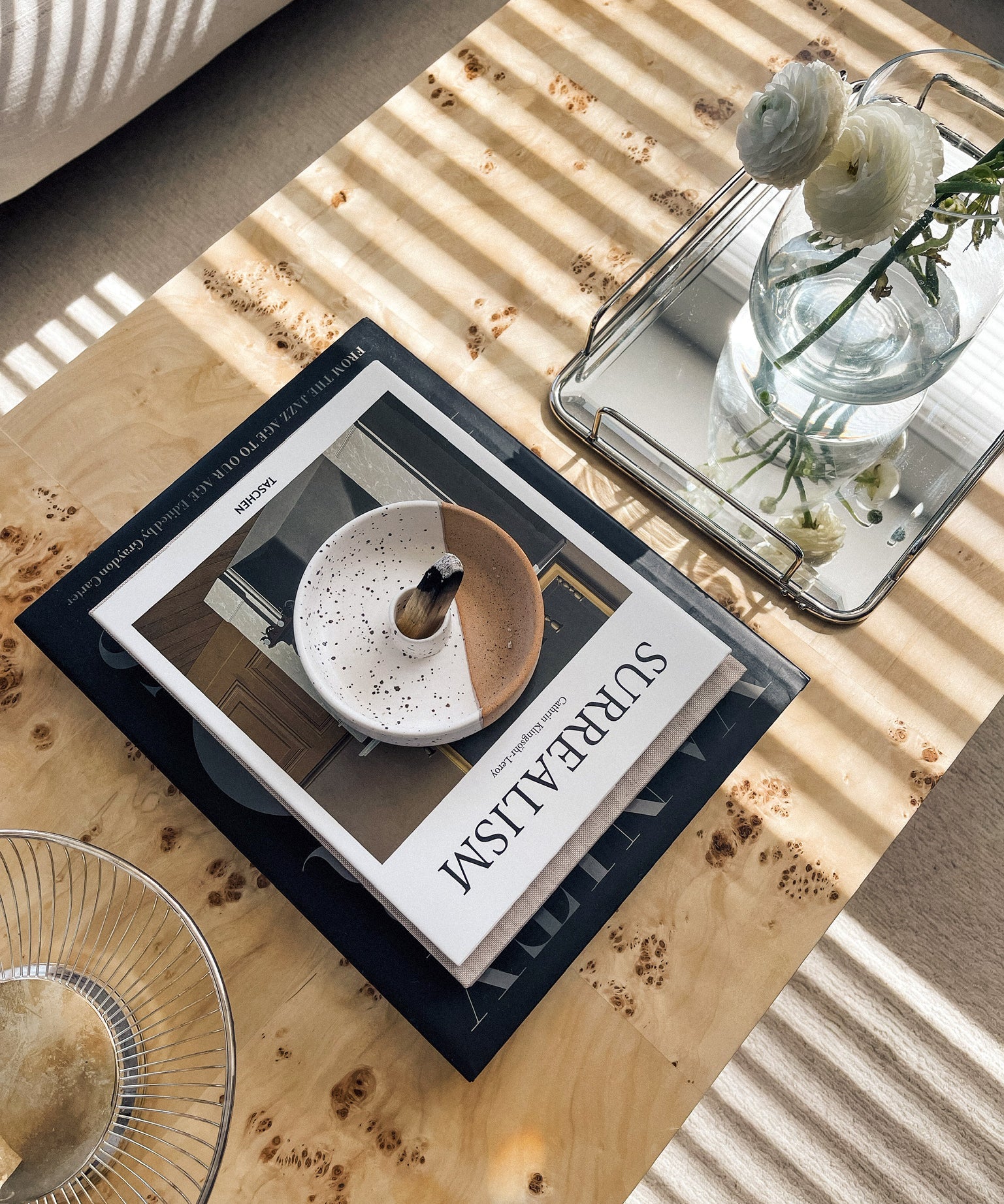 Book titled 'Surreal' on a wooden table with decorative items.