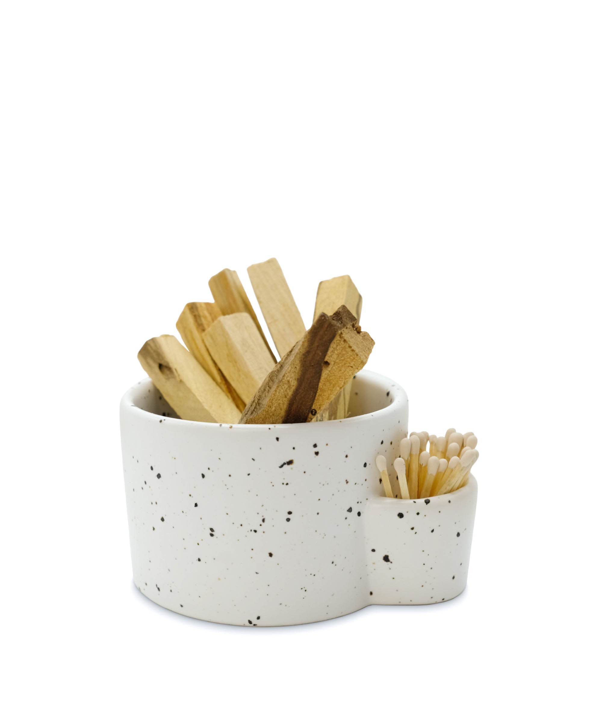 Speckled ceramic container with wooden sticks and a small bowl on a white background