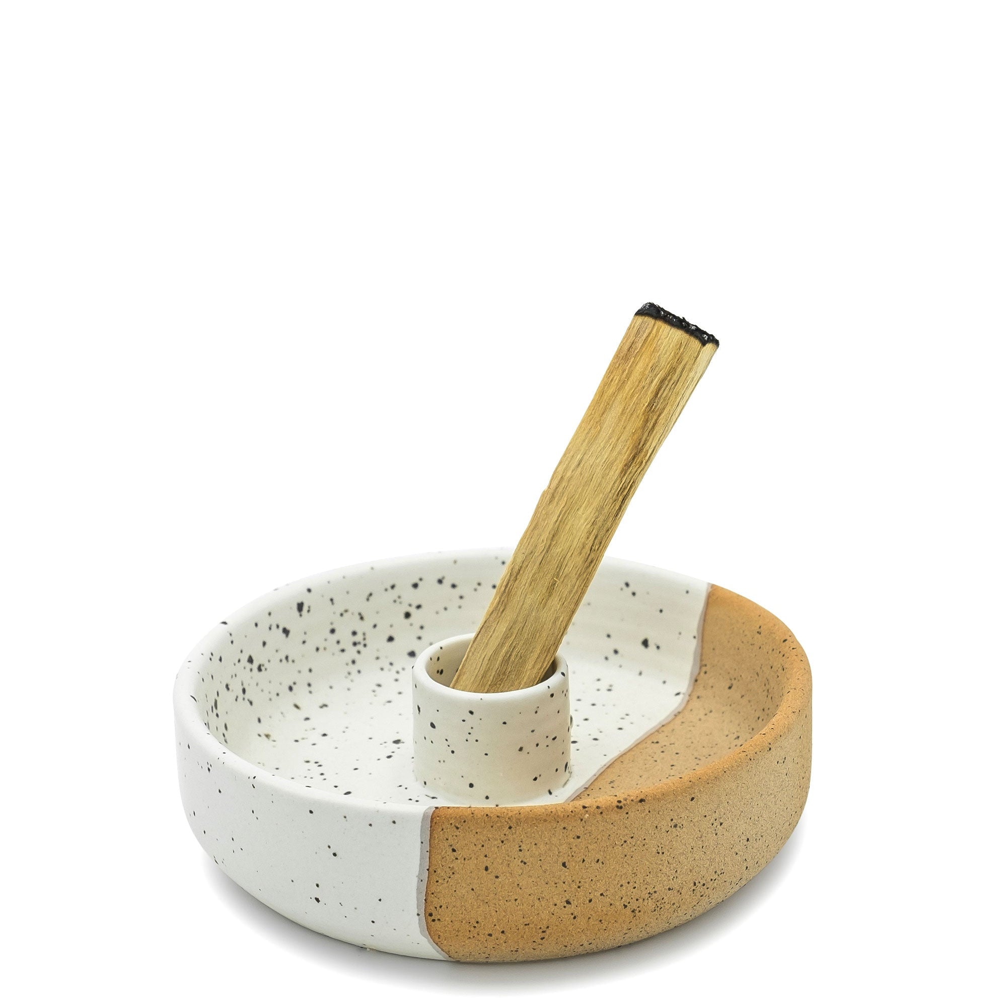 Ceramic bowl with speckled pattern and wooden spoon on a white background