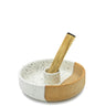 Ceramic bowl with speckled pattern and wooden spoon on a white background