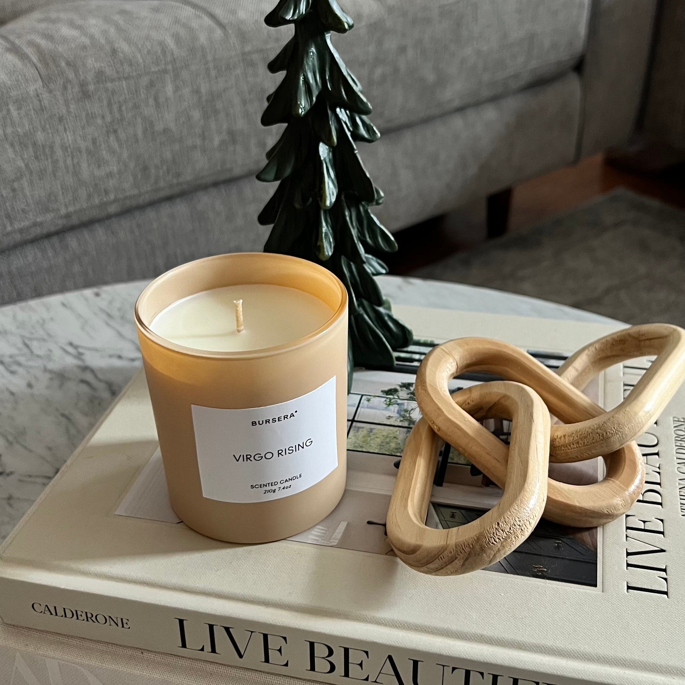 Candle on a stack of books with decorative items on a coffee table