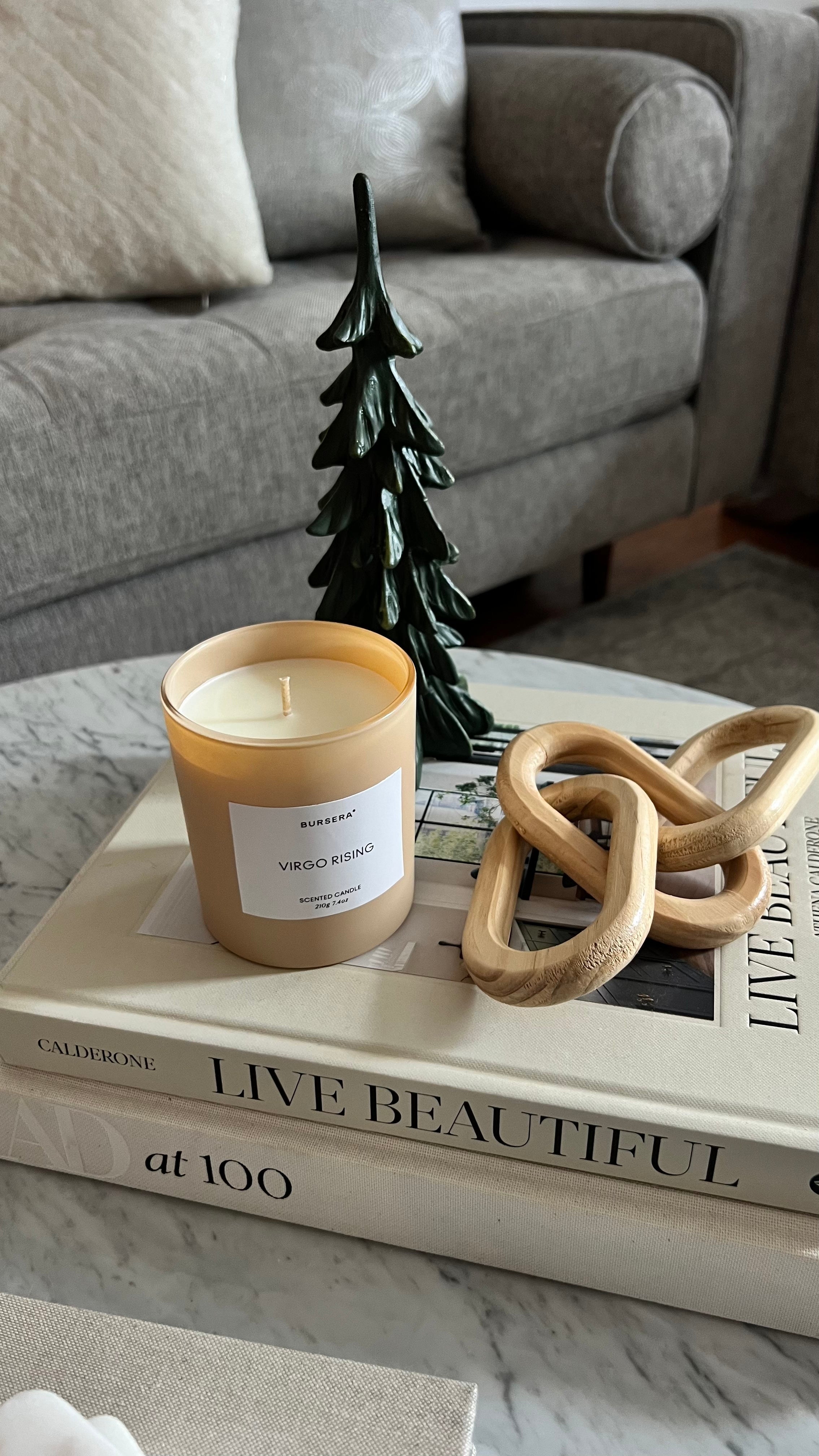 Candle on a stack of books with decorative items on a coffee table