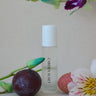Skincare bottle labeled 'CARDEA AUSSET' with a plum and flowers on a beige background