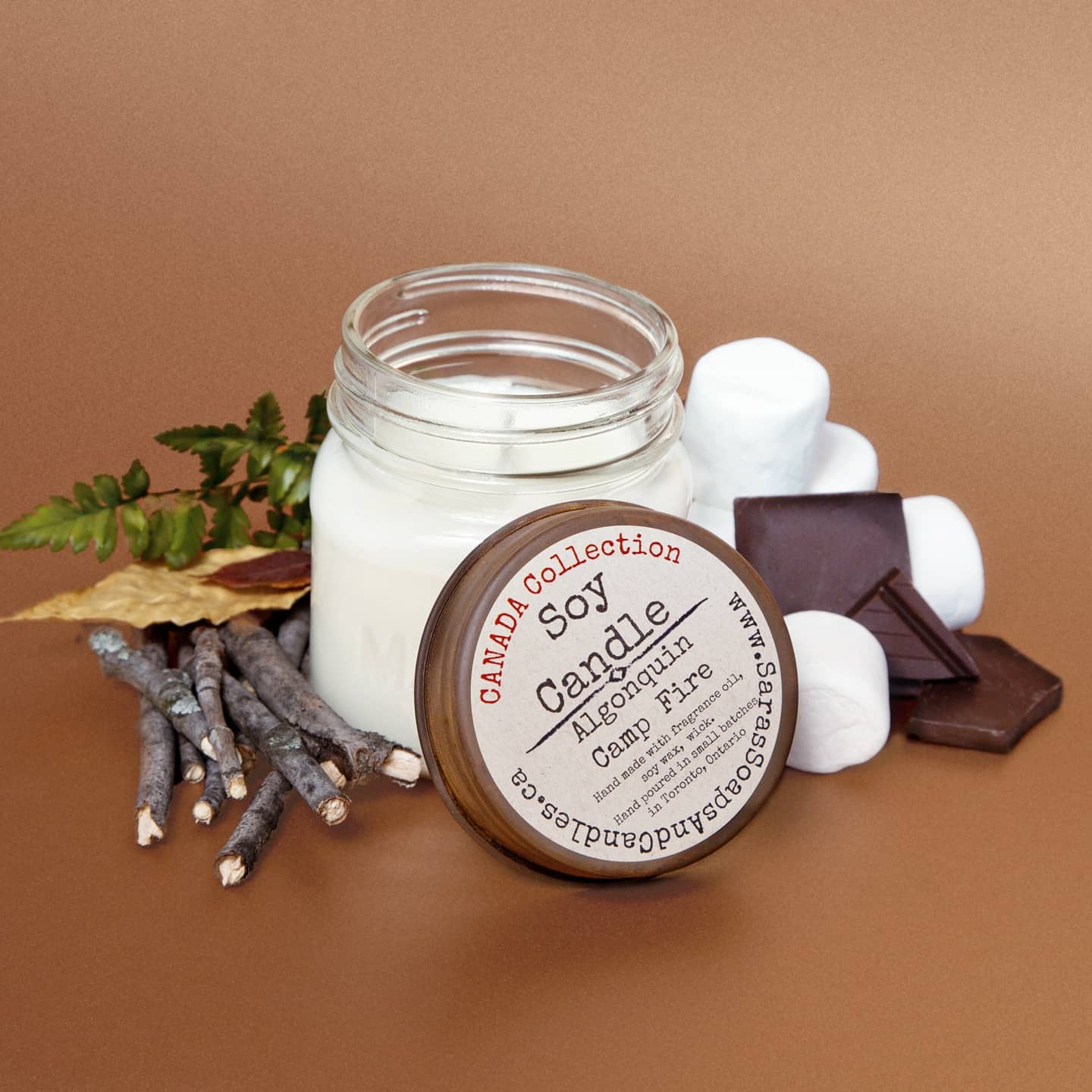 Soy candle in a glass jar with decorative elements on a brown background