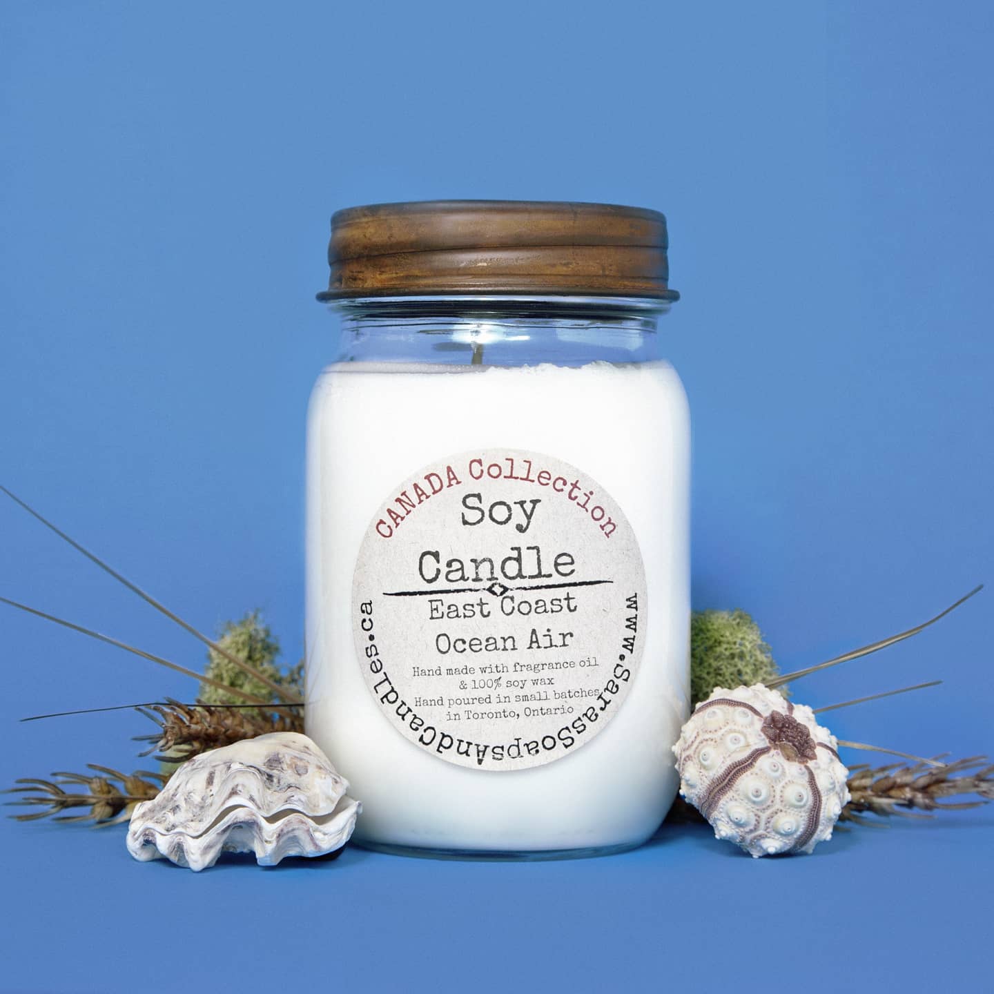Soy candle in a glass jar with a wooden lid on a blue background from Stop and Smell the Candles