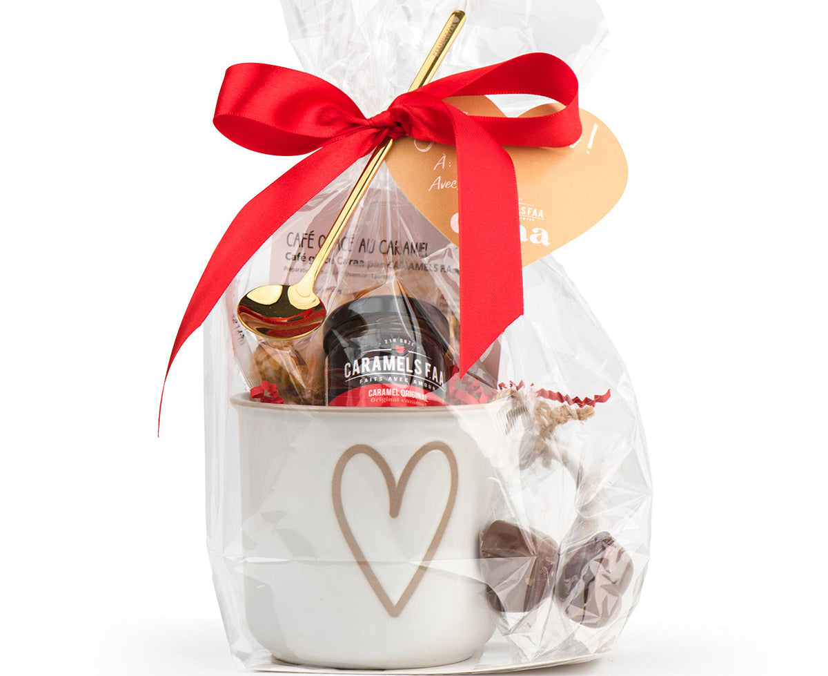 Gift set with a mug, cookies, and a red ribbon on a white background