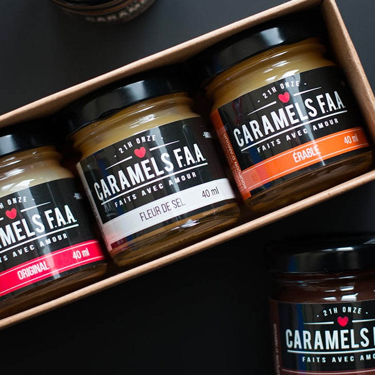 Three jars of Caramels Faar on a black surface with a box.