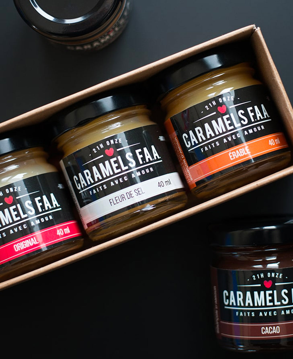 Three jars of Caramels Faar on a black surface with a box.