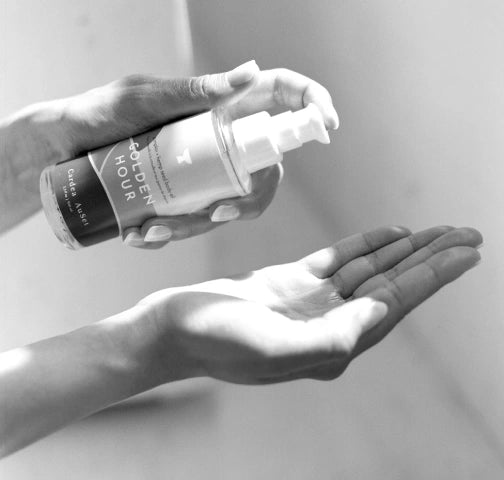Hand holding a Cardea AuSet Golden Hour Body oil against a neutral background