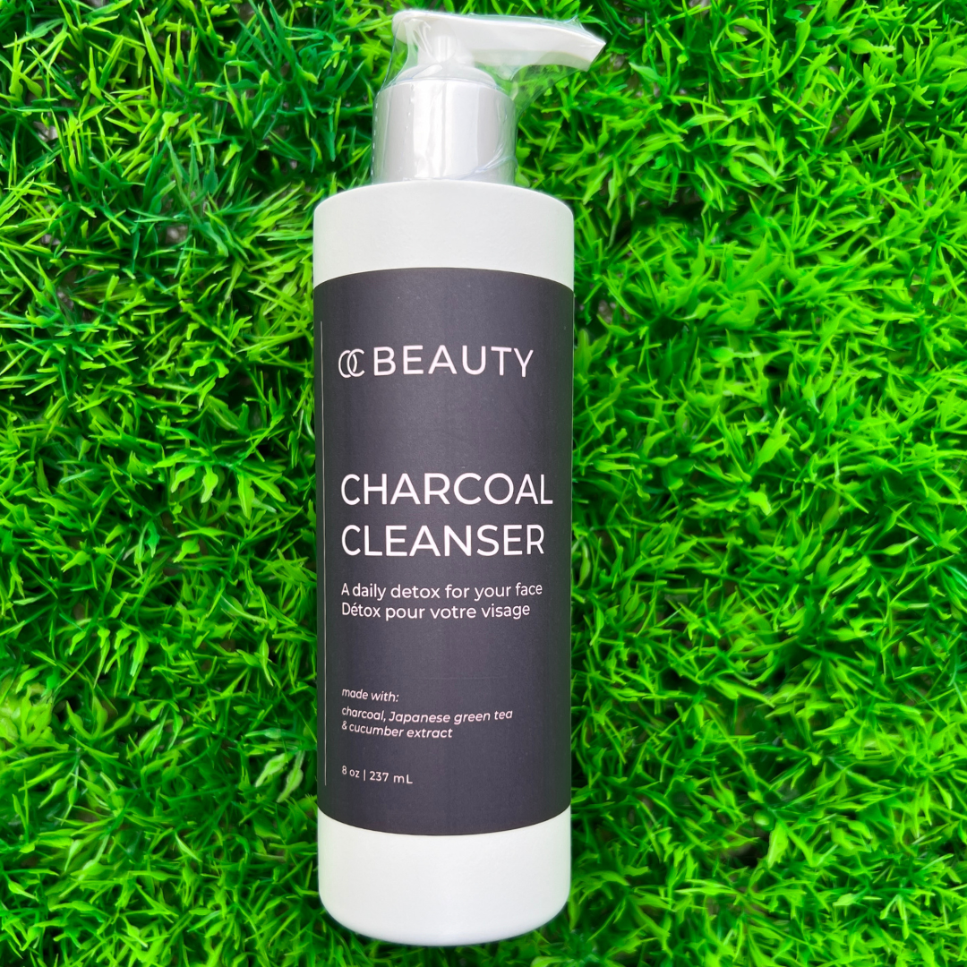 OC Beauty Charcoal Cleanser bottle on a grass background