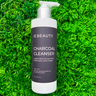 OC Beauty Charcoal Cleanser bottle on a grass background