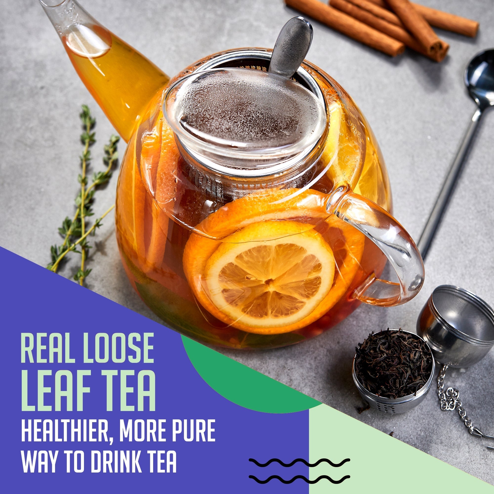 Teapot with lemon slices and cinnamon sticks, surrounded by tea leaves and a spoon on a gray surface.