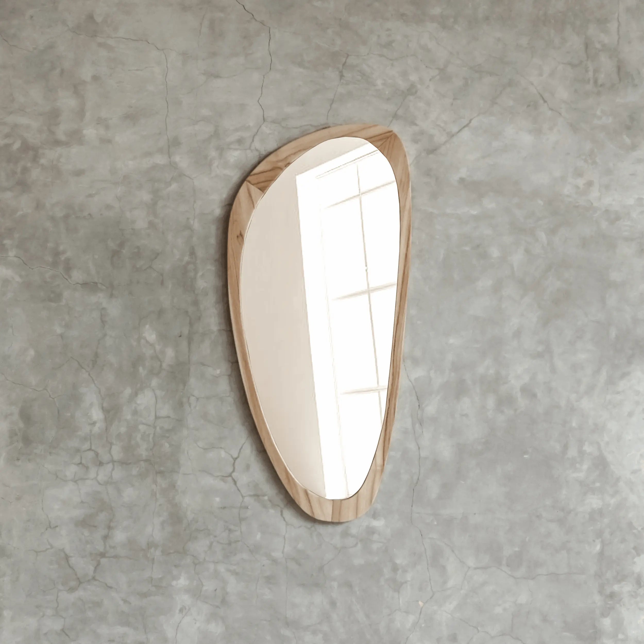 Crusoë Peninsula mirror styling with a light interior on a textured gray wall