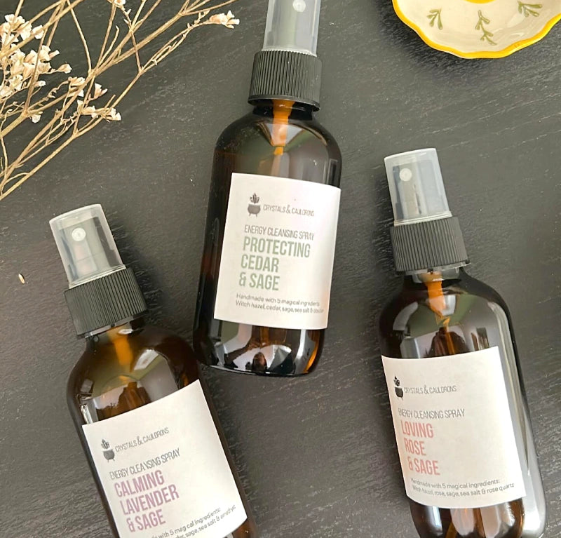 Three brown spray bottles with labels on a dark surface.