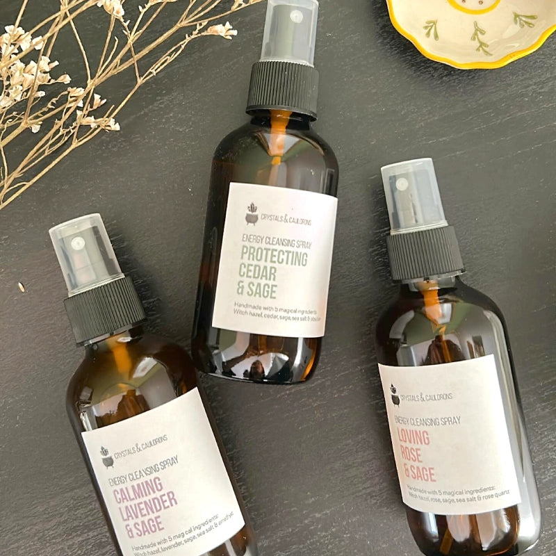 Three brown spray bottles with labels on a dark surface.