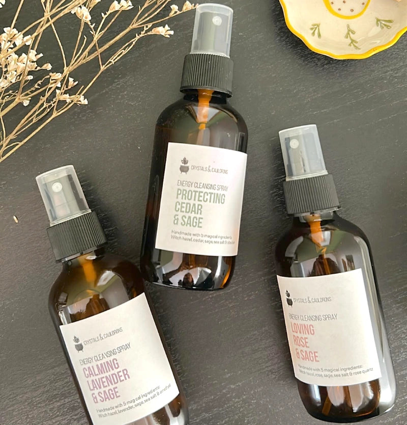 Three brown spray bottles with labels on a dark surface.