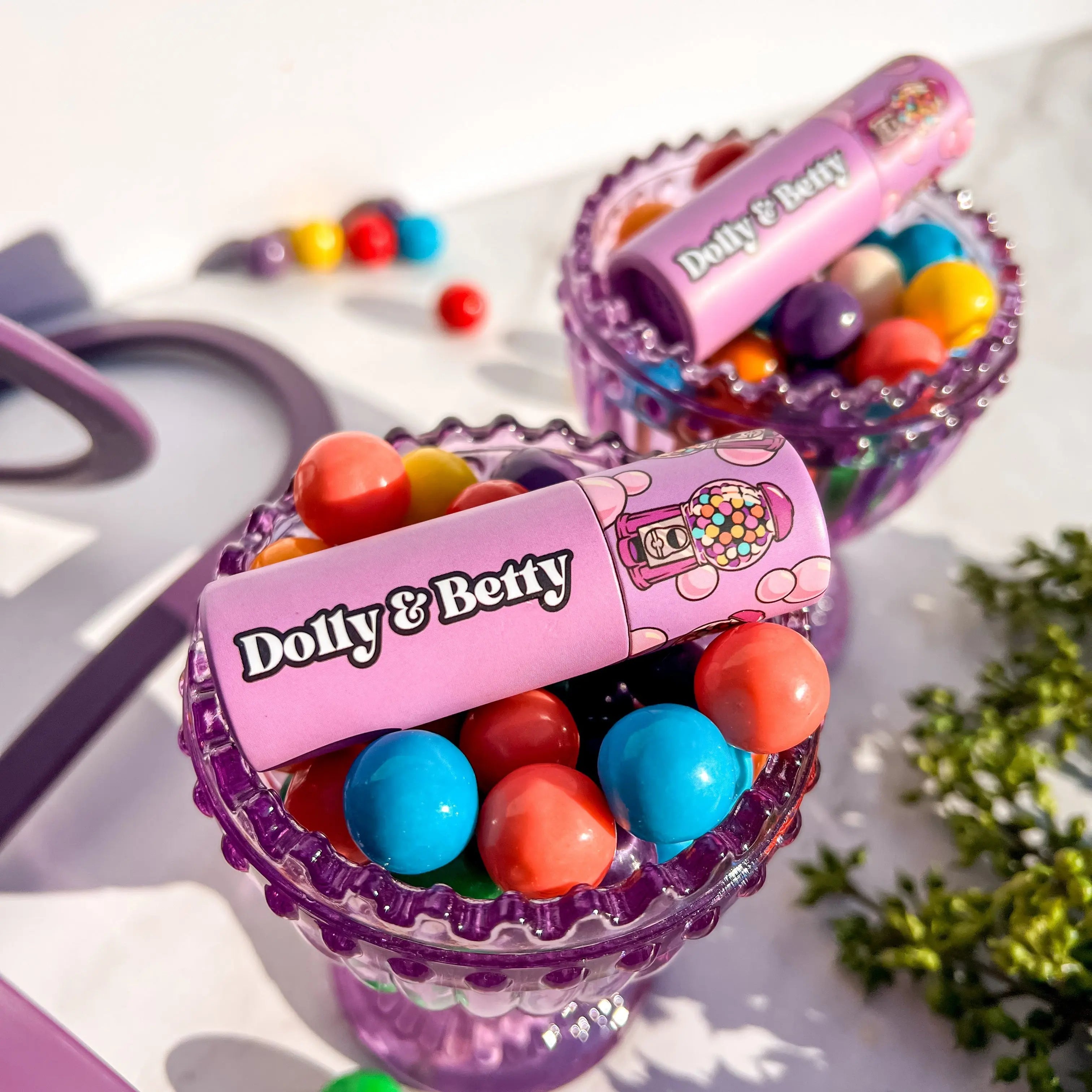 Two colorful candy containers with 'Dolly & Betty' branding on a white background.