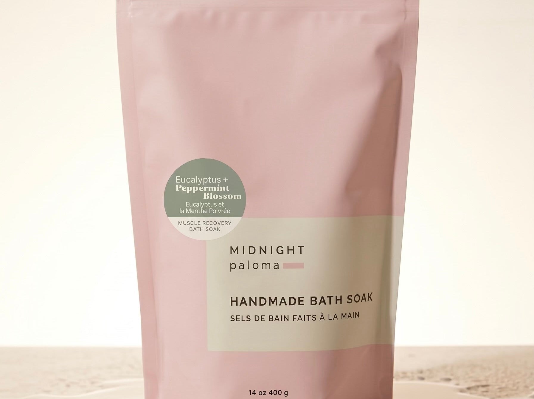 Handmade bath soak packaging with pink and beige design on a light background