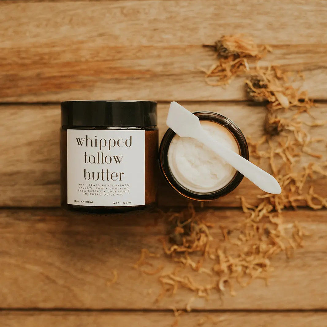 Jar of whipped butter with a knife on a wooden surface