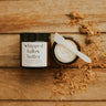 Jar of whipped butter with a knife on a wooden surface