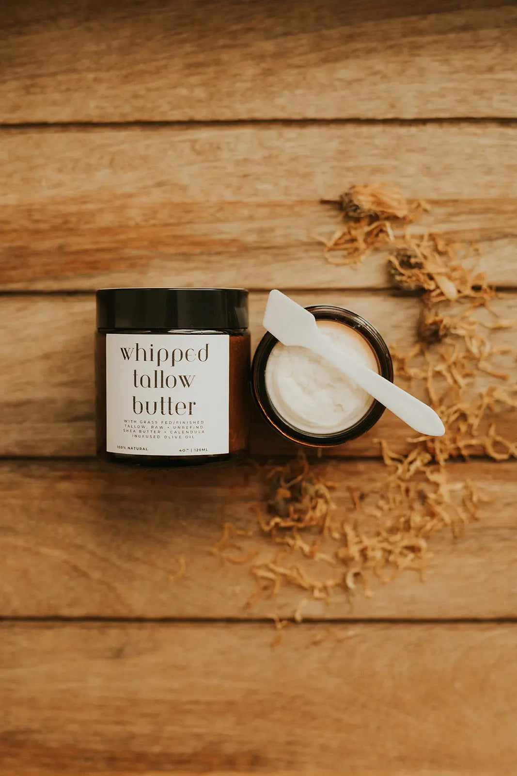 Jar of whipped butter with a knife on a wooden surface