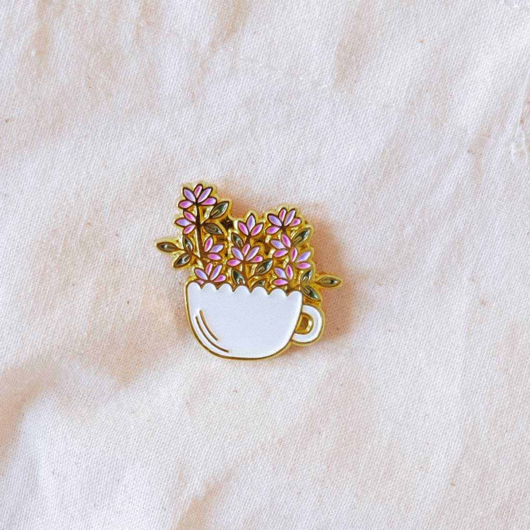 Floral cup pin on a white fabric background mimi-and-august