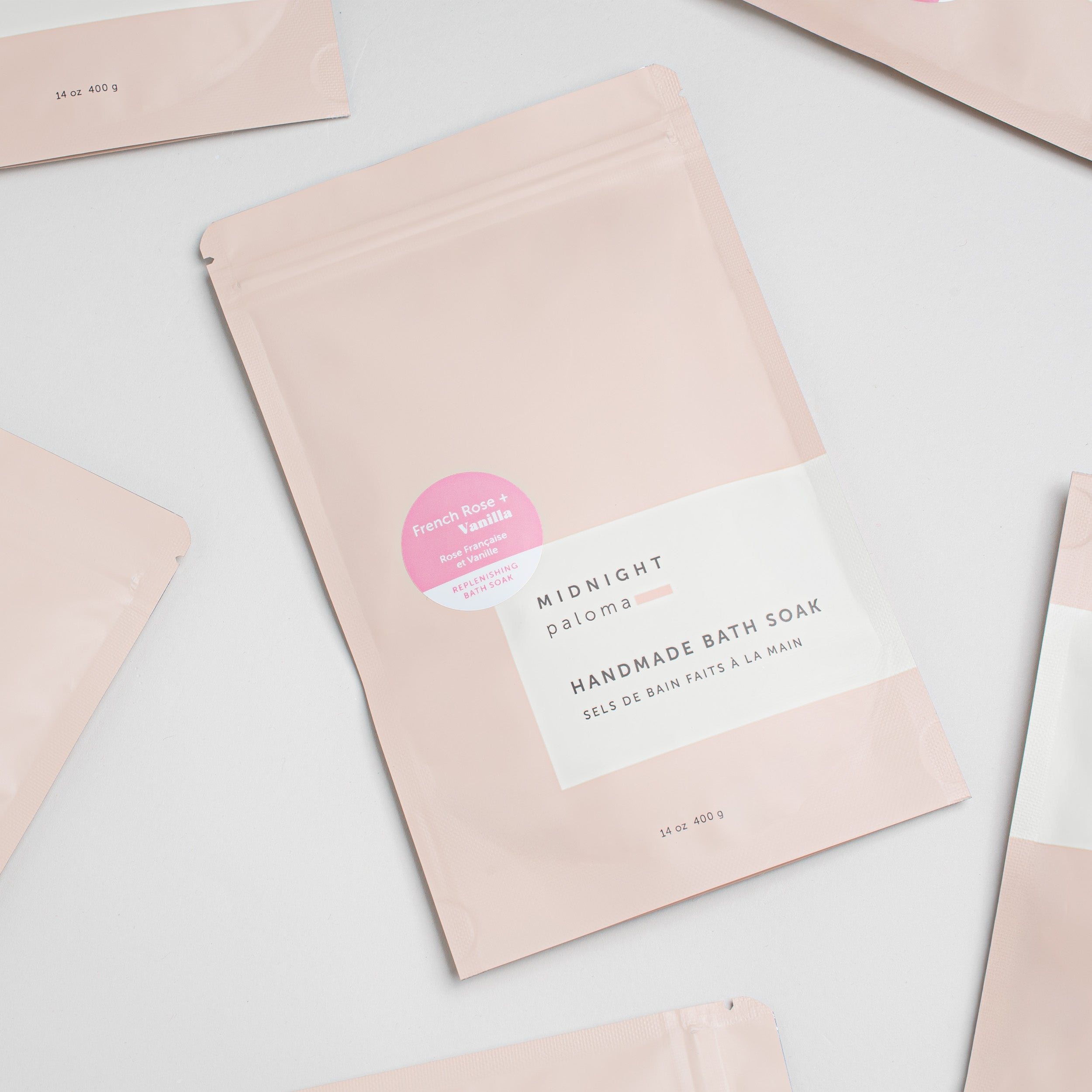 Handmade bath soap packaging with pink and white design on a light gray background